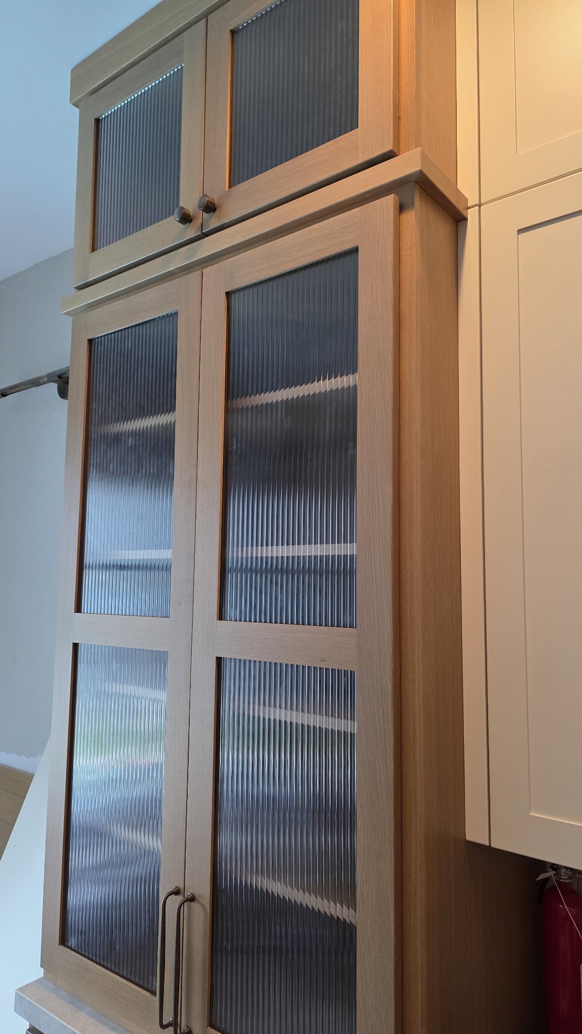 Glas Plus cabinet glass example: tall wood cabinet with reeded glass doors