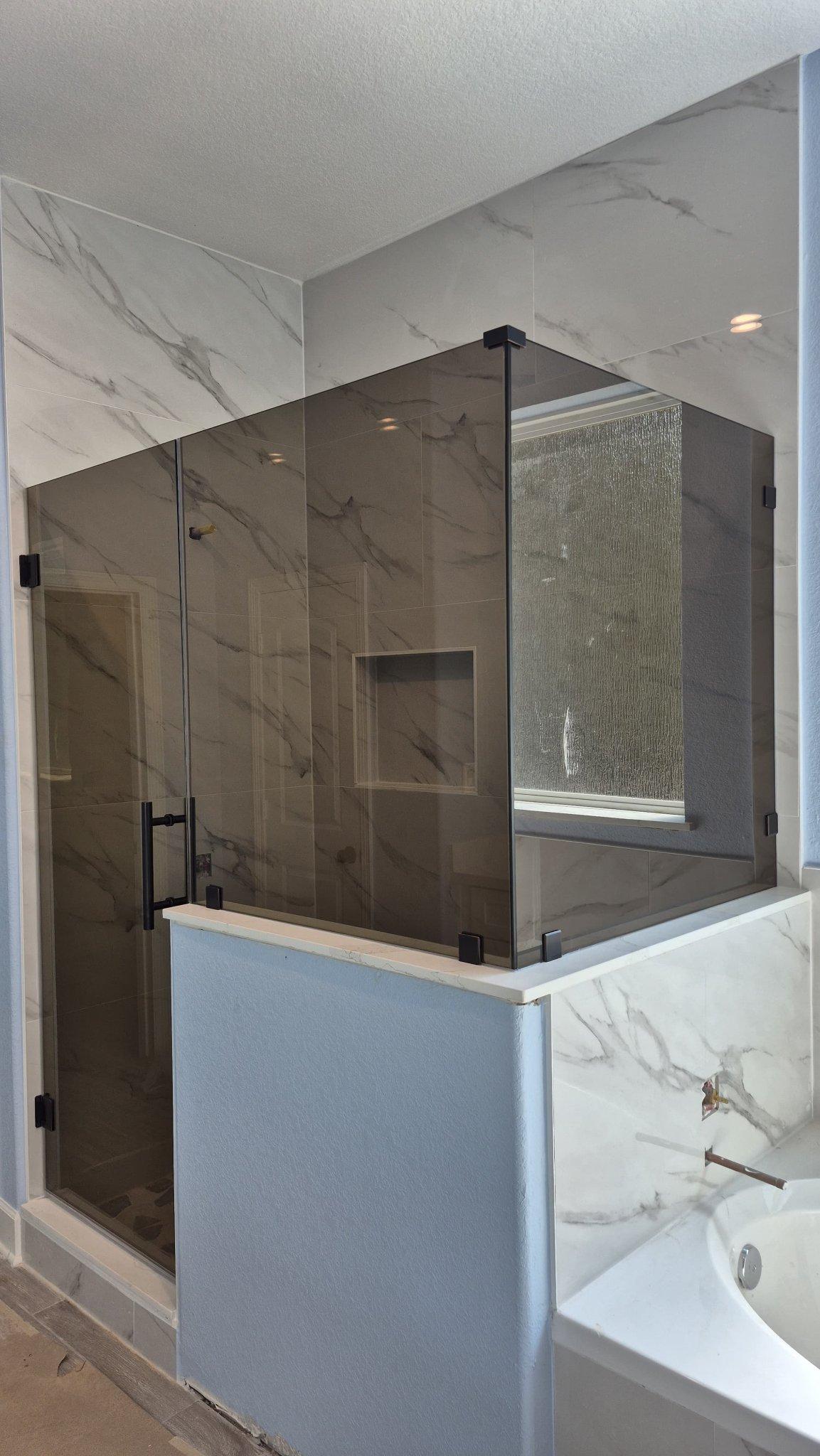 Glas Plus job: 90° angle shower with Bronze glass (bronze tone) over a wall, next to the tub
