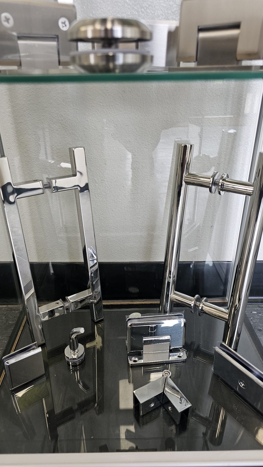 Glas Plus chrome hardware set in a display case: handles, hinges and clips in a bright chrome finish