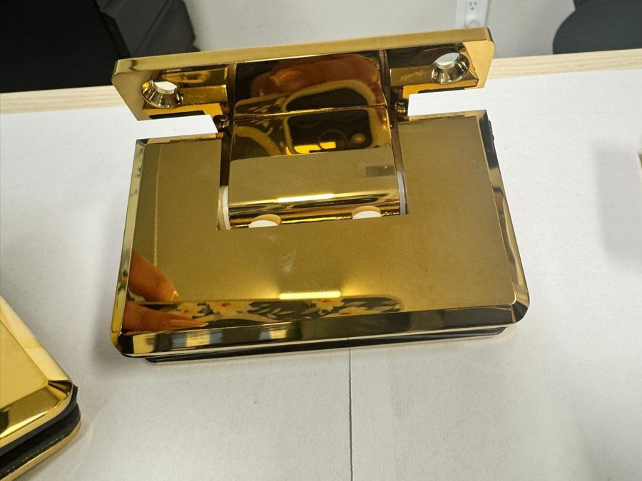 Glas Plus polished gold hinge on a white table