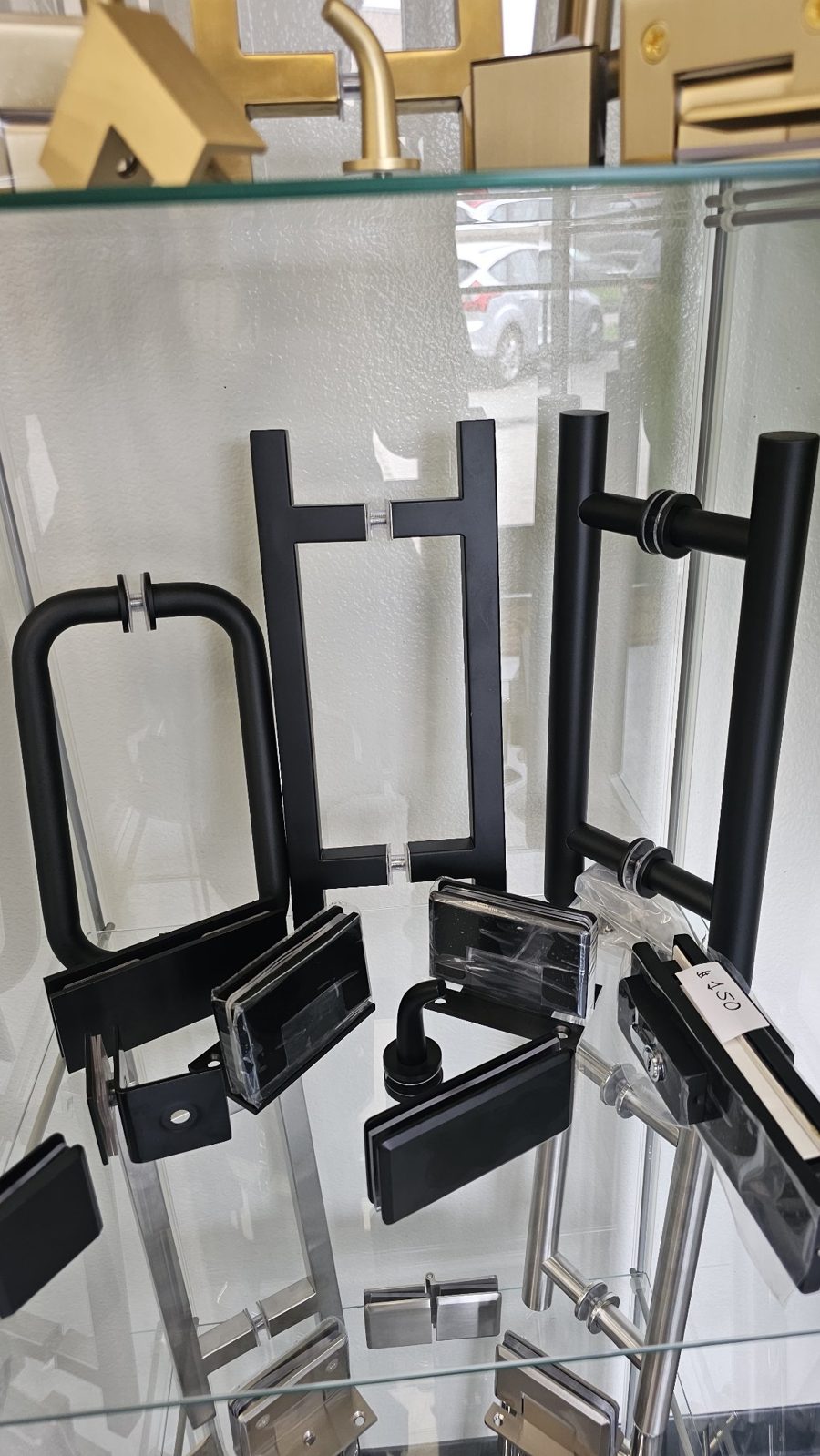 Glas Plus matte black hardware set in a display case: handles and hinges in matte black