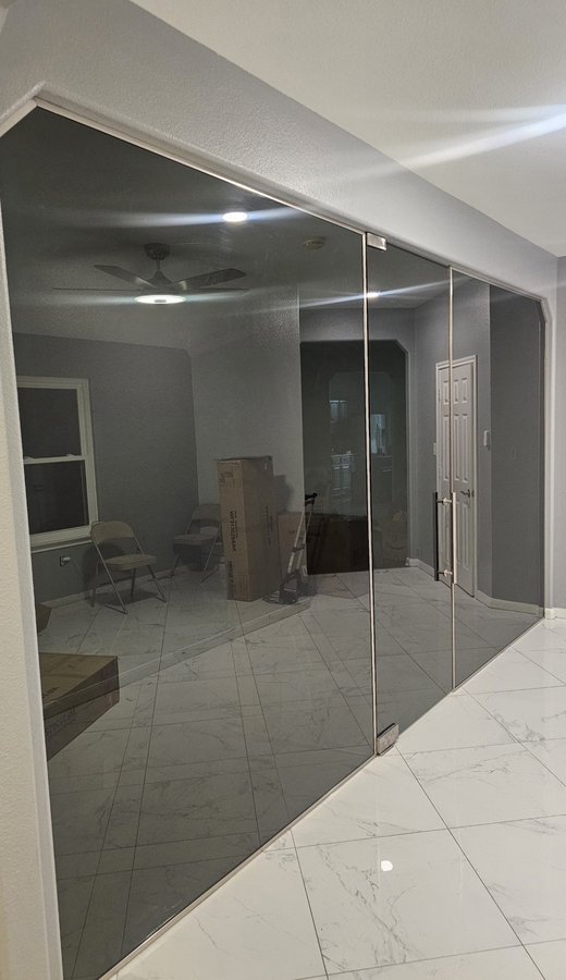 Glas Plus special orders example: frameless smoked glass partition wall with a door, inside a house