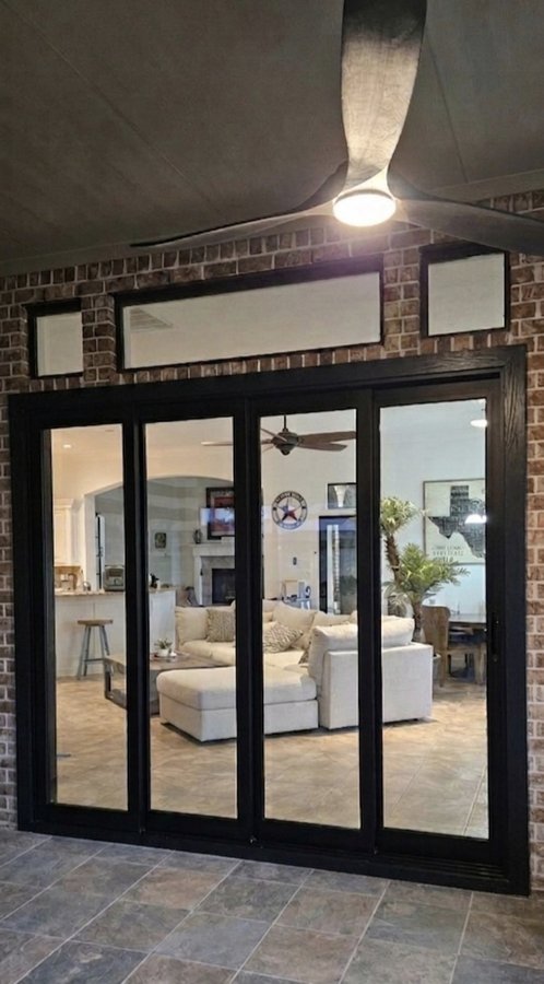 Glas Plus patio doors example: glass patio doors with a black frame and top panels, seen from the patio