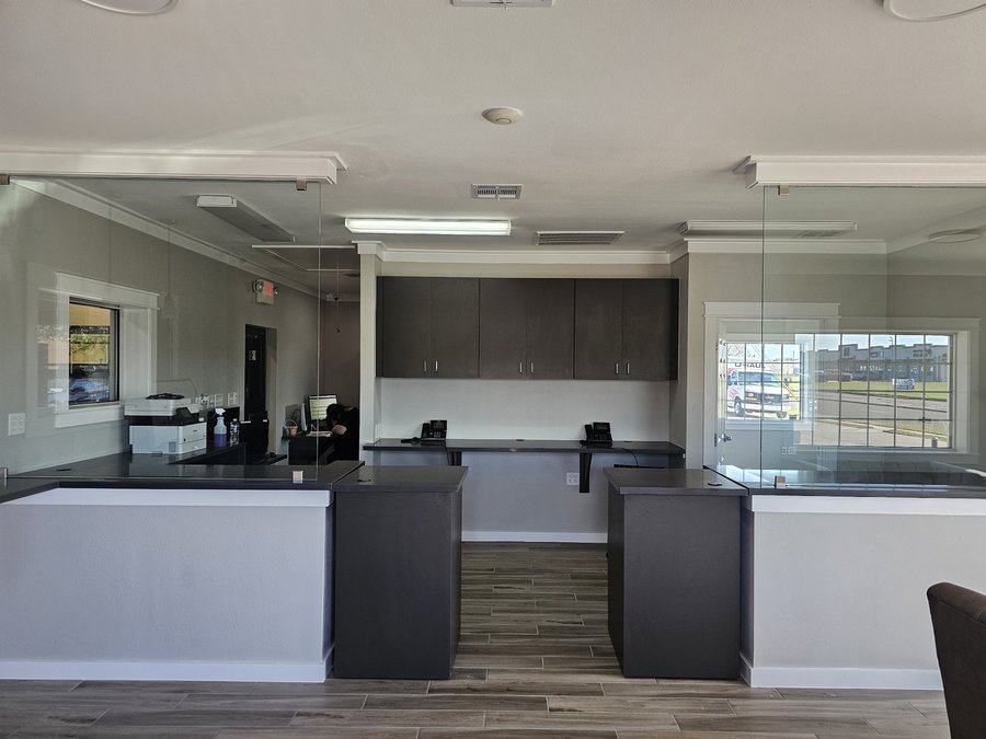 Glas Plus storefront example: frameless glass partitions over counters in an office