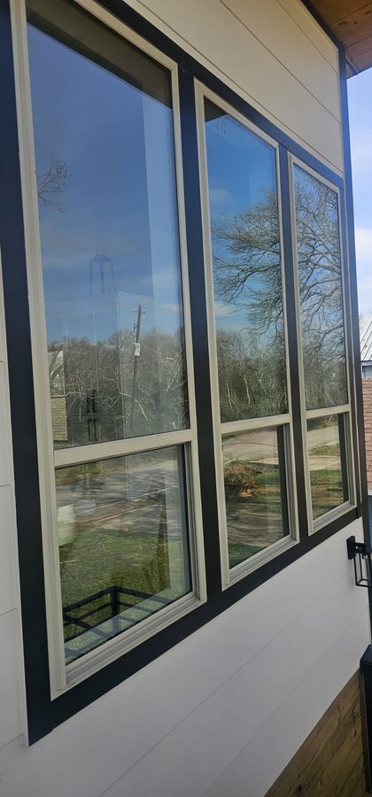 Glas Plus windows example: three tall windows with white and black frames on the front of a house