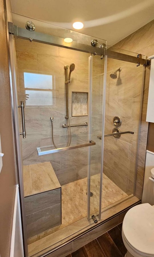 Double-door sliding with glass return and chrome hardware in a marble shower