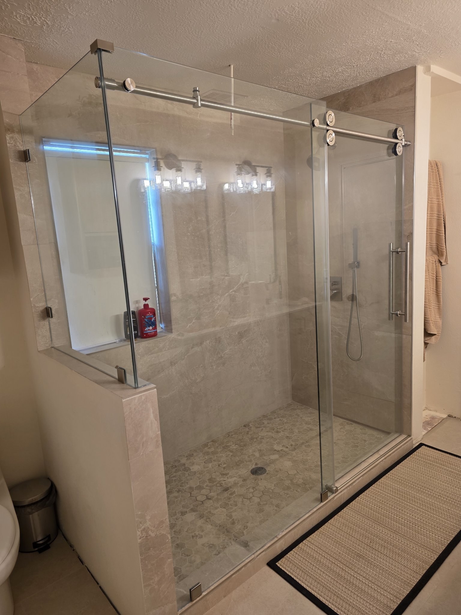 Sliding with return over a half wall with chrome hardware in a beige tile shower