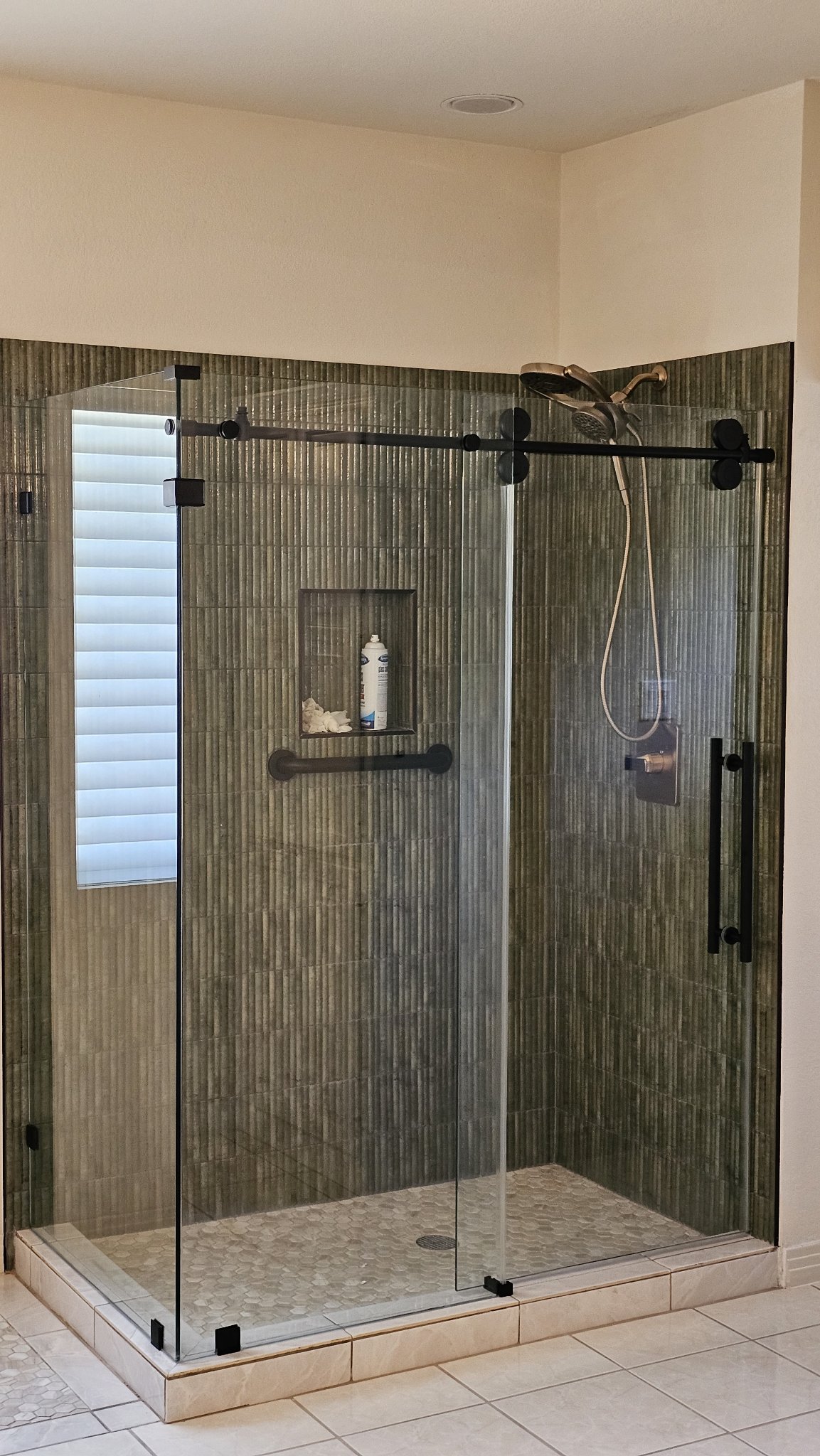 Sliding with return reference photo: sliding door and fixed panel at the front on a track, with a 90° return glass in the corner, black hardware