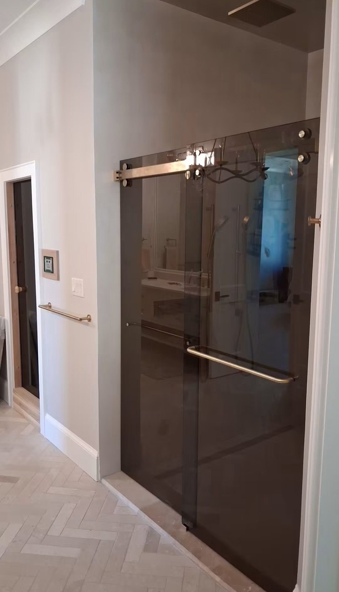 Double-door sliding with Bronze glass (bronze tone) and brush nickel track at the entrance of a shower